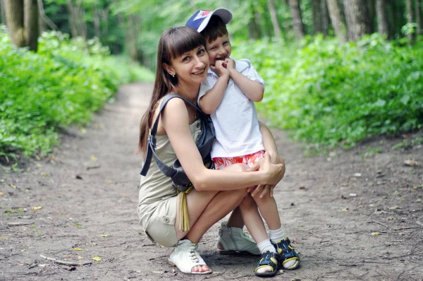 Kleiner glücklicher Junge mit seiner Mutter bei einem Spaziergang im Park — Stockfoto