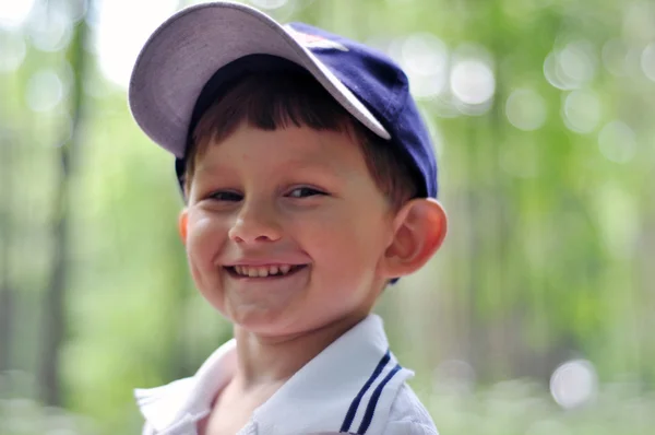 Маленький щасливий усміхнений хлопчик у парку — стокове фото