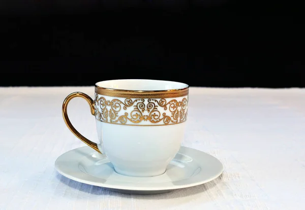 Eine Weiße Tasse Tee Mit Goldenem Aufdruck Auf Einem Tisch — Stockfoto