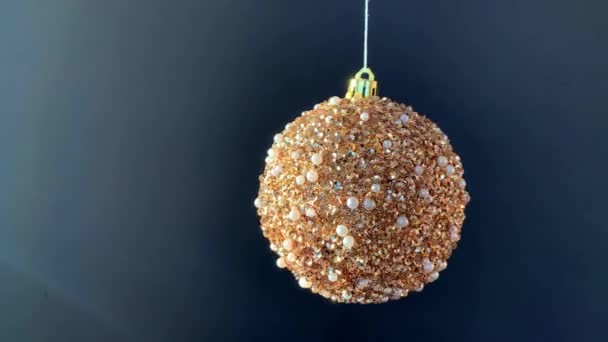 Een Gouden Glanzende Glitter Kerstbal Beweegt Draait Witte Draad Zwarte — Stockvideo