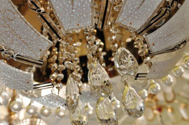 Sumptuous golden abstract background with shiny chrystals of chandelier close up