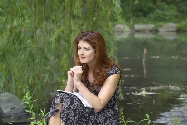 Mädchen sitzt im Park und ärgert sich — Stockfoto