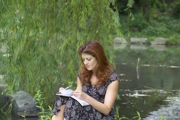 Ragazza che scrive nel parco — Foto Stock