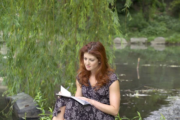 Ragazza che scrive nel parco — Foto Stock