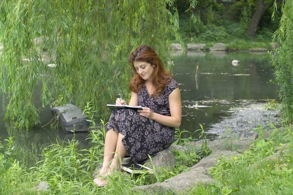 Mädchen schreibt im Park — Stockfoto