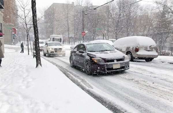 BRONX, NEW YORK - JANUARY 21: Street traffic during a 6 to 10 inch snow storm with teen temperatures along Ogden avenue and 162nd street. Taken January 21, 2014 in the Bronx, New York.