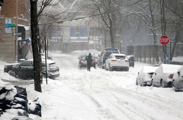 BRONX, NEW YORK, USA - January 29, 2022: Person walking street during snow storm.