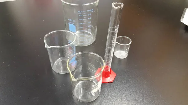 Science classroom beakers graduated cylinders and other volume measuring equipment.