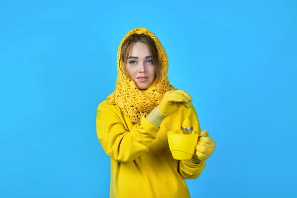 Девушка Делает Чай Кружке Женщина Жёлтой Одежде Шарфе Голубой Фон — стоковое фото