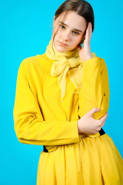 Sarı elbiseli genç bir kızın portresi. mavi arkaplan