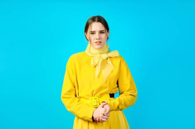 Sarı elbiseli genç bir kızın portresi. mavi arkaplan