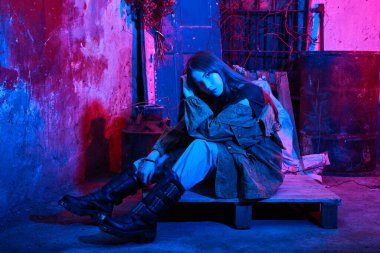 Terk edilmiş bir binada güzel bir kızın neon ışıklı portresi.