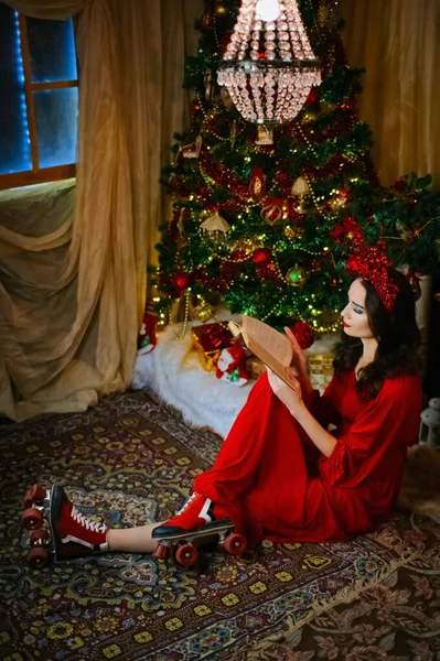 女性はクリスマスツリーの近くでクリスマスに本を読み — ストック写真