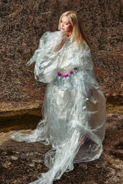 Moda yaratıcı. Plastik şişelerle selofanda poz veren bir model. konsept