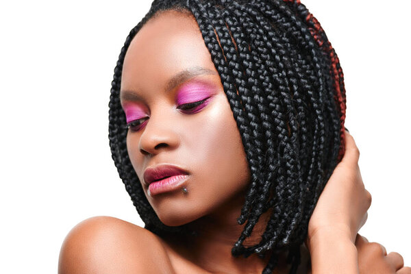 beauty portrait of an african american girl closed eyes. pink visage make-up. white background. isolate