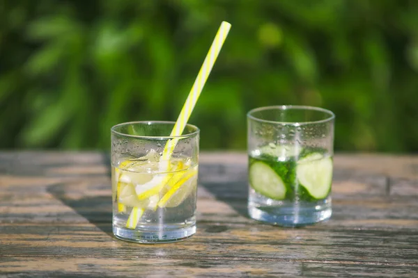 Taze limon ve salatalık limonatası. Bardakta saman içmek. Suda doğranmış meyve dilimleri