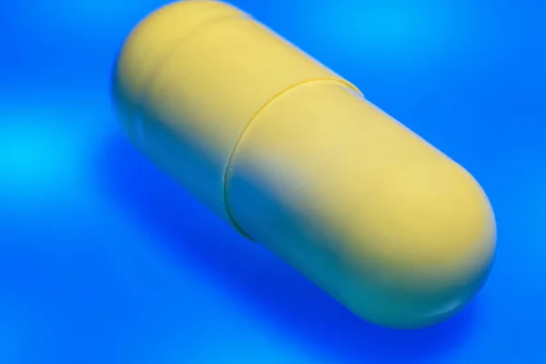 Sárga Kapszula Tabletták Záródnak Makró Kék Háttér — Stock Fotó