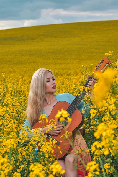 Sahada gitar çalan seksi bir kadın. konsept özgürlük, ilham, rahatlama