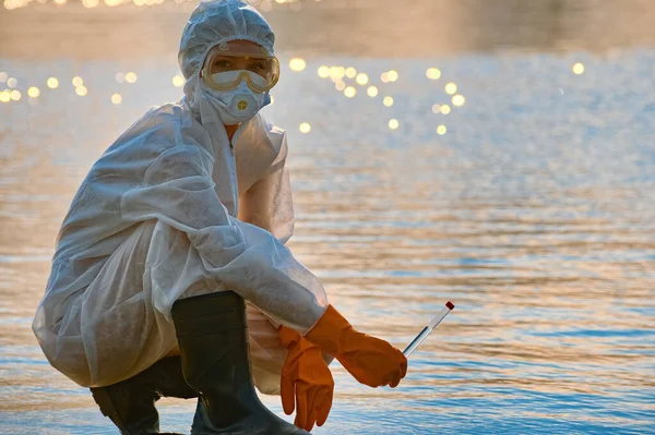 Koruma giysisi ve maskesi olan bir uzman tarafından suyu kontrol ediliyor.