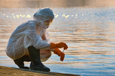 checking the water by a specialist in a protective suit and mask clipart