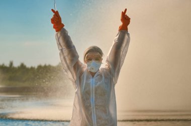 Koruma giysisi ve maskesi olan bir uzman tarafından suyu kontrol ediliyor.