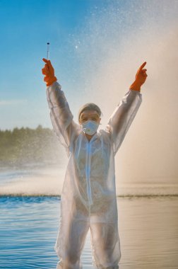 Koruma giysisi ve maskesi olan bir uzman tarafından suyu kontrol ediliyor.