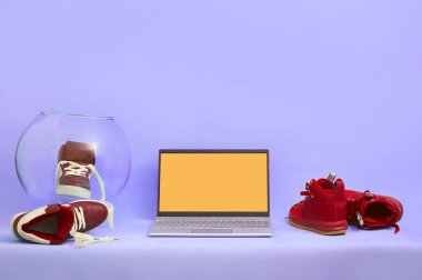 Masadaki bordo ayakkabıların üzerindeki gümüş dizüstü bilgisayar. kopyalama alanı. maketleme.