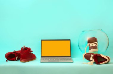 Masadaki bordo ayakkabıların üzerindeki gümüş dizüstü bilgisayar. kopyalama alanı. maketleme.