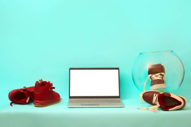 Masadaki bordo ayakkabıların üzerindeki gümüş dizüstü bilgisayar. kopyalama alanı. maketleme.