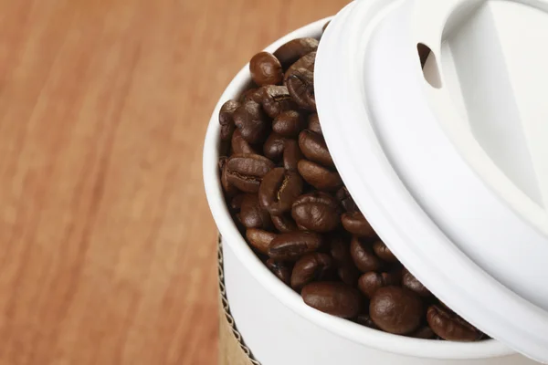 Granos de café en taza de papel — Foto de Stock