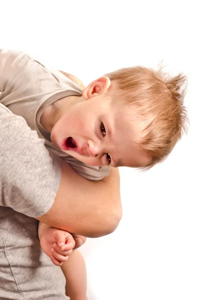 Ein kleiner hübscher Junge gähnt auf Händen — Stockfoto