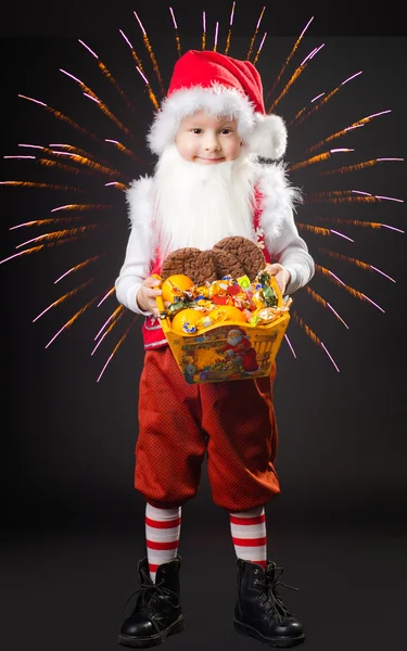 Boy in the suit of gnome with sweetnesses in hands — Stock Photo, Image