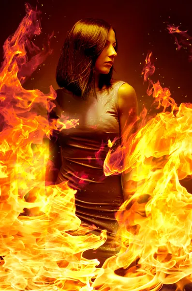 Krásná mladá dívka je v hořící plamen — Stock fotografie