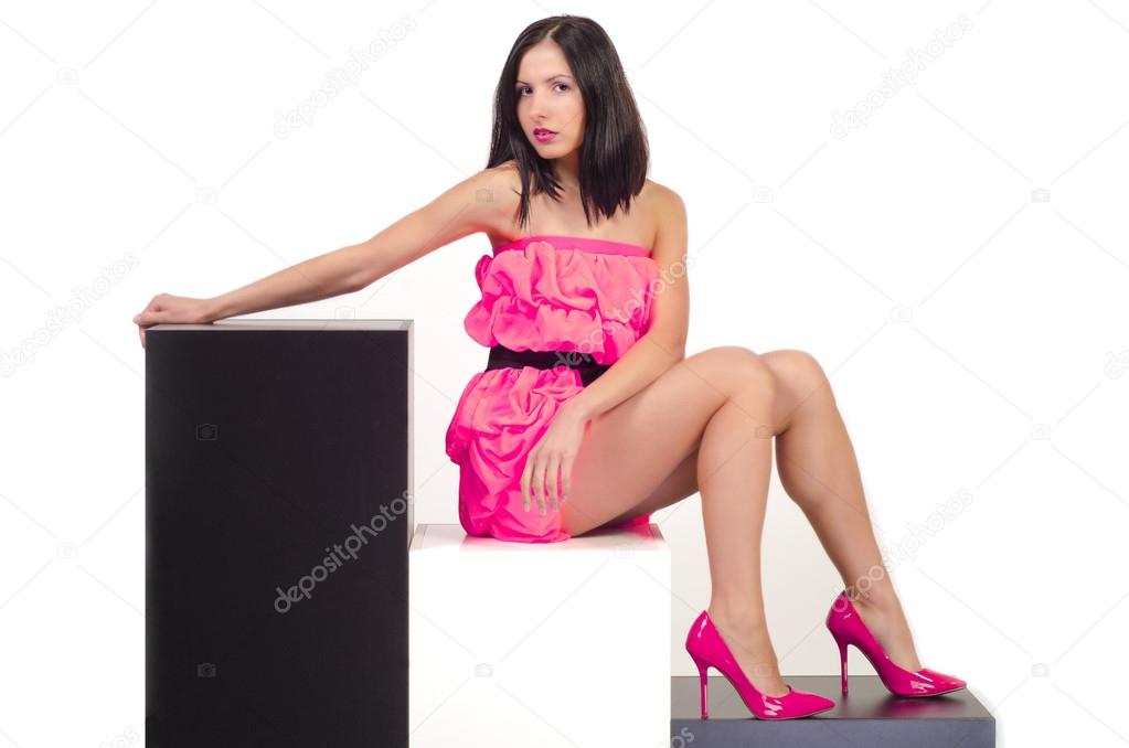Beautiful sexual girl in pink dress sits on cubes