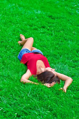 genç güzel ince kadın rahatlatıcı çim üzerinde yalan