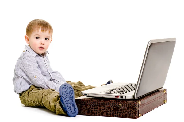 Schattige kleine jongen zittend op de vloer met een laptop — Stockfoto