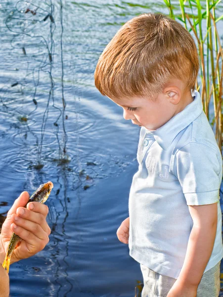 Bekantskap en liten pojke med en fisk — Stockfoto