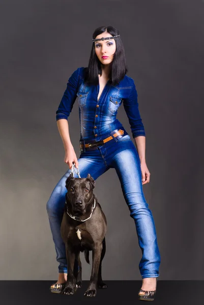 Hermosa joven de pie junto a un staffordshire terrier — Foto de Stock