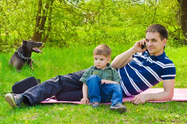 Hombre con hijo y perro al aire libre hablando por teléfono — Foto de Stock