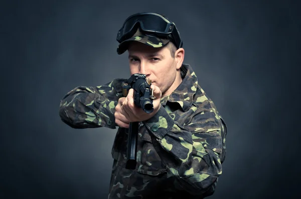 Soldat syftar en kulspruta med fokus på fat maskinen — Stockfoto