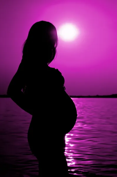 Silhouet van een zwangere vrouw in het maanlicht — Stockfoto