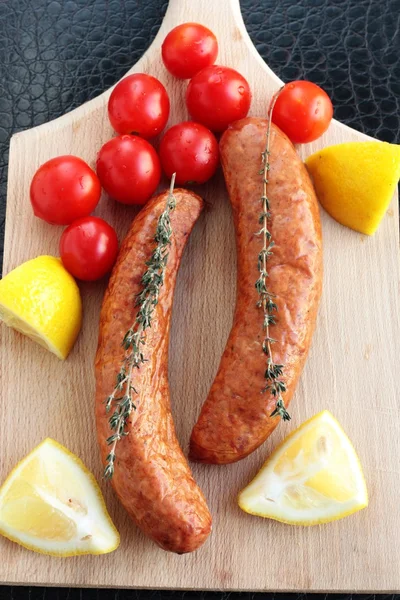 Sausages with cherry tomatoes, lemon and thyme — Stock Photo, Image