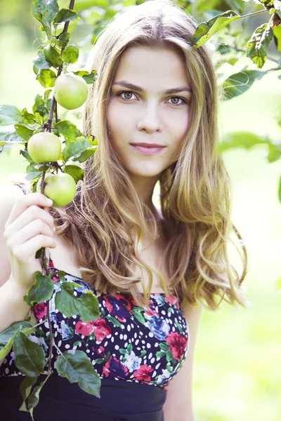 Красивая молодая девушка, стоящая возле яблони — стоковое фото