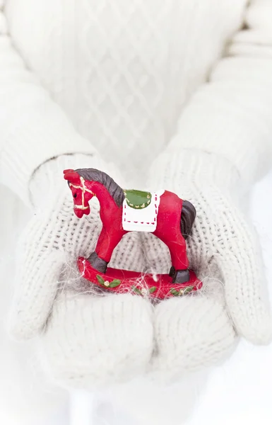 Christmas toy horse in the girls hands Royalty Free Stock Photos