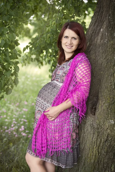 Pregnant woman in a shawl in the park — Stock Photo, Image