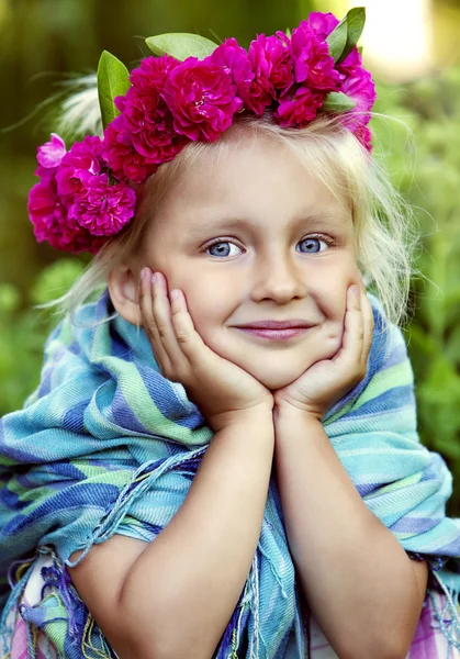 Portrait of little girl in a wreath from roses Stock Image
