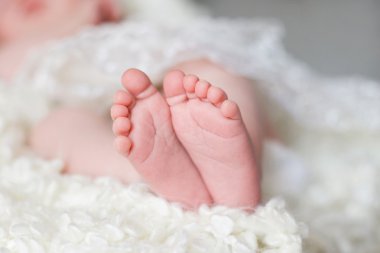 Yeni doğan bebeğin ayakları üzerinde beyaz bir battaniye