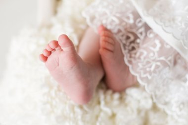 Yeni doğan bebeğin ayakları üzerinde beyaz bir battaniye. seçici odak