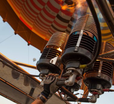 Çalışan bir hava balonu ocağından ateş edin. Pilot sıcak hava balonunu propan gazıyla dolduruyor. 