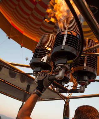 Çalışan bir hava balonu ocağından ateş edin. Pilot sıcak hava balonunu propan gazıyla dolduruyor. 